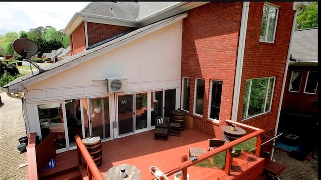 rear view of property featuring brick siding and a deck