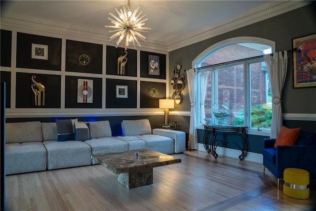sitting room with crown molding, a chandelier, and wood finished floors