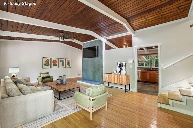 living area featuring stairway, wood ceiling, wood finished floors, baseboards, and a ceiling fan