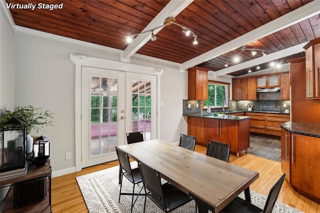 dining room featuring wood ceiling, light wood-type flooring, french doors, rail lighting, and beamed ceiling