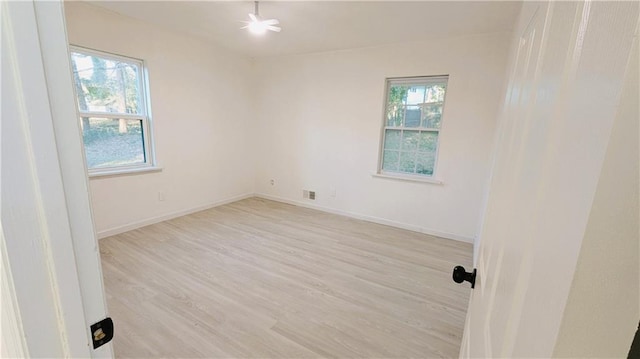 spare room featuring a healthy amount of sunlight and light hardwood / wood-style flooring