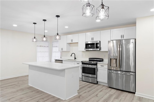 kitchen with pendant lighting, sink, white cabinets, a center island, and stainless steel appliances