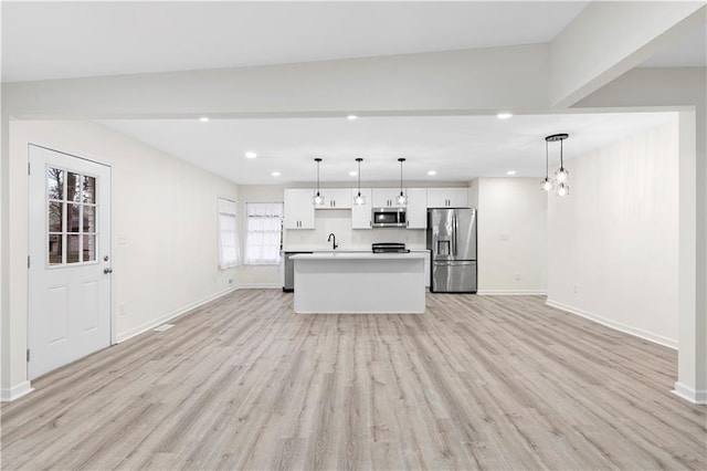 kitchen with white cabinets, a kitchen island, stainless steel appliances, light hardwood / wood-style floors, and hanging light fixtures