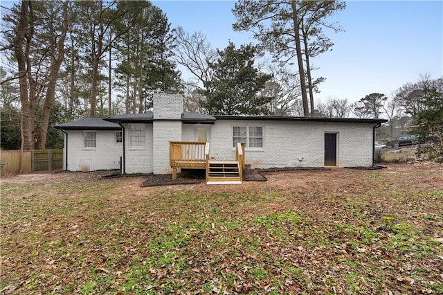 back of house with a wooden deck and a lawn