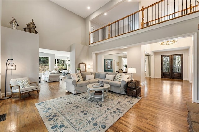 living room with a chandelier, hardwood / wood-style flooring, and baseboards