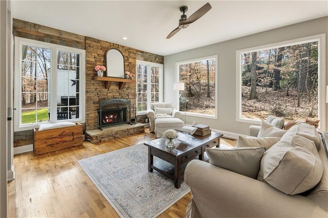 living room featuring a ceiling fan, a fireplace, and hardwood / wood-style floors