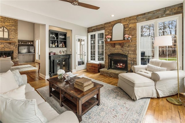 living room featuring a bar, wood-type flooring, a fireplace, and baseboards