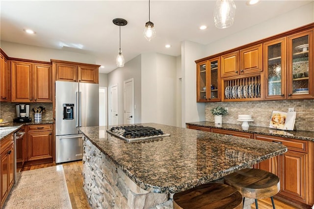 kitchen featuring stainless steel appliances, light wood-type flooring, and brown cabinets