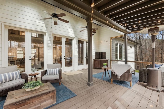 wooden deck with an outdoor hangout area, french doors, and a ceiling fan