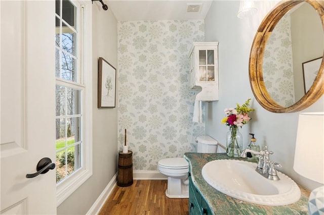 full bath with visible vents, toilet, vanity, wood finished floors, and baseboards