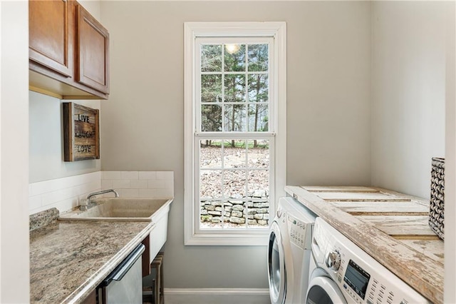 laundry area with plenty of natural light, independent washer and dryer, cabinet space, and baseboards