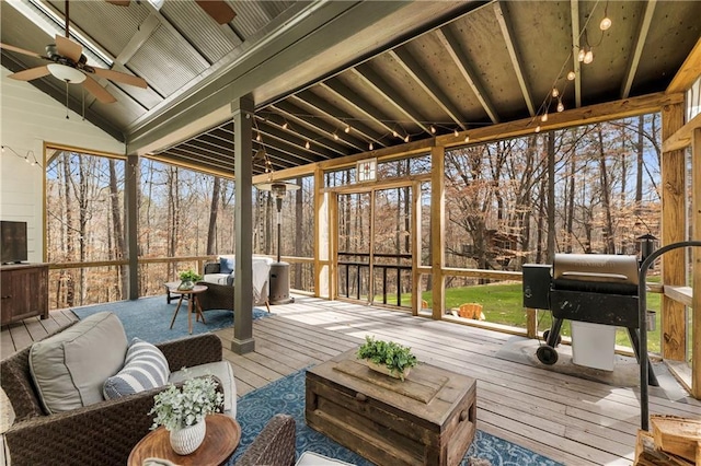 sunroom featuring lofted ceiling and ceiling fan