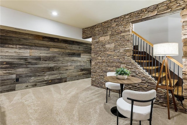 interior space featuring wooden walls, carpet flooring, and stairway