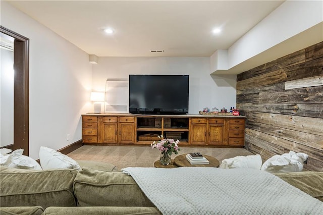 living room featuring light carpet, wood walls, baseboards, and recessed lighting