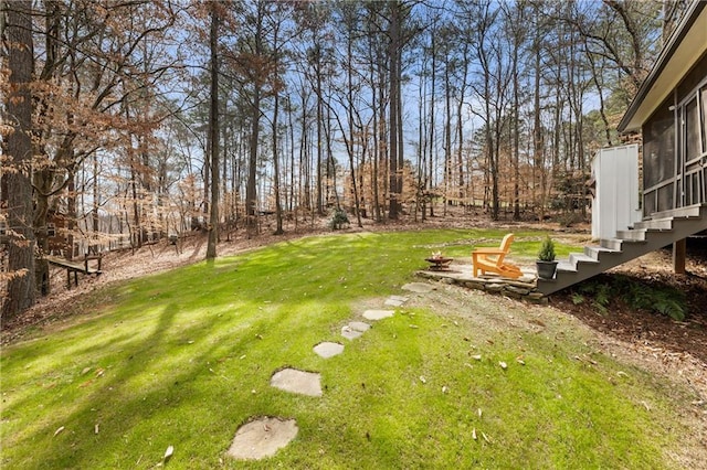 view of yard with an outdoor fire pit, a sunroom, and stairway