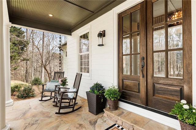 doorway to property featuring a porch and french doors