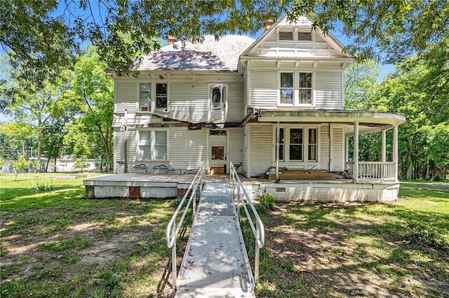 view of front of home with covered porch and a front lawn