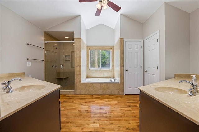 bathroom featuring a sink, wood finished floors, two vanities, and a shower stall