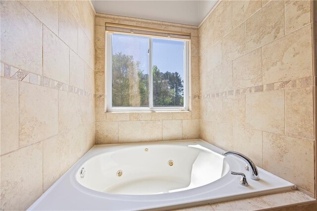 bathroom featuring tile walls, plenty of natural light, and a whirlpool tub