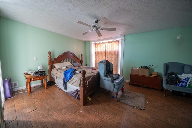 bedroom with hardwood / wood-style floors, a textured ceiling, and ceiling fan