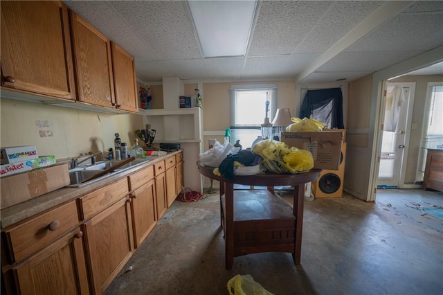 kitchen featuring a paneled ceiling, sink, and concrete floors