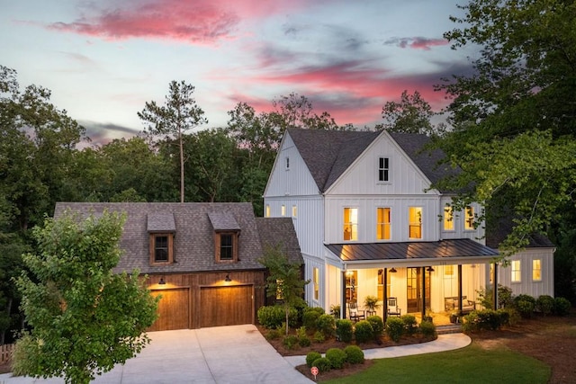 modern farmhouse style home featuring covered porch, board and batten siding, a standing seam roof, roof with shingles, and concrete driveway