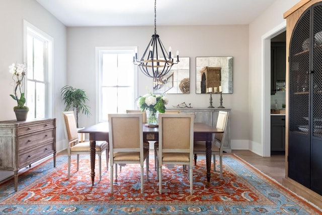 dining area with an inviting chandelier, baseboards, and wood finished floors