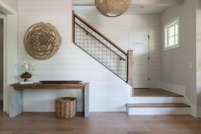 staircase featuring wood walls and wood finished floors