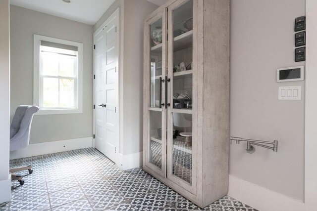 unfurnished office featuring tile patterned floors and baseboards