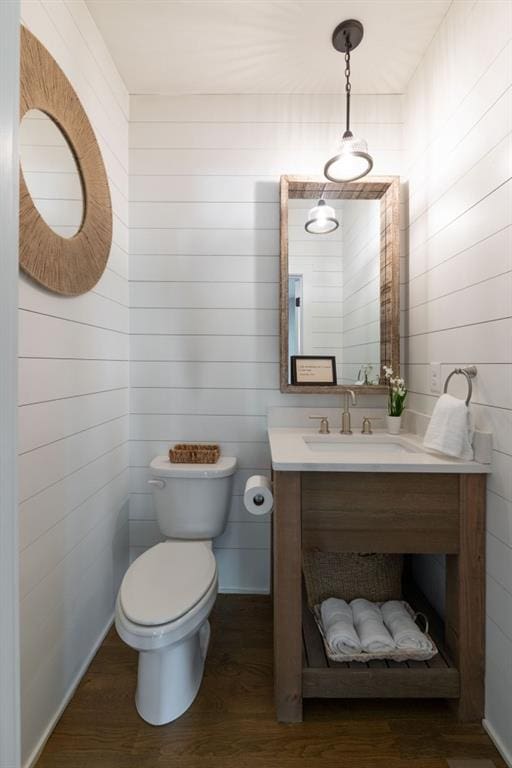 bathroom with toilet, wood finished floors, and vanity