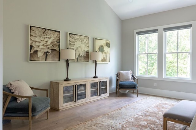 living area with baseboards and wood finished floors