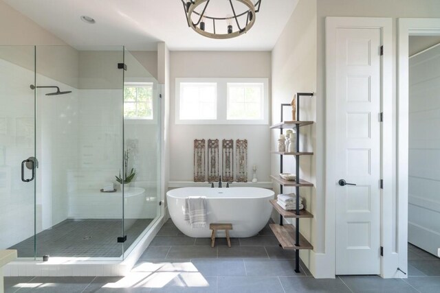 full bath featuring a freestanding tub, a shower stall, and tile patterned flooring
