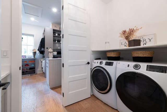 laundry room featuring washing machine and clothes dryer, laundry area, attic access, and light wood-style floors