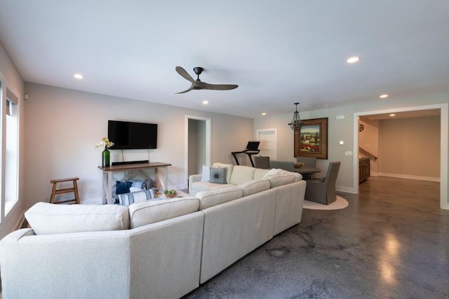 living area with recessed lighting, ceiling fan, concrete flooring, and baseboards