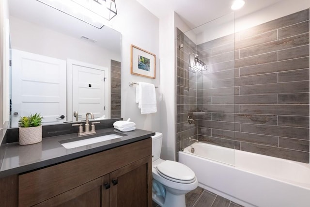 bathroom featuring visible vents, wood finished floors, vanity, toilet, and bathing tub / shower combination