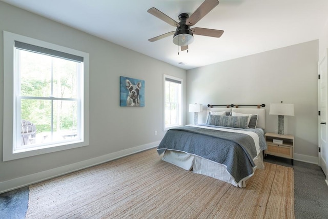 carpeted bedroom featuring baseboards and ceiling fan