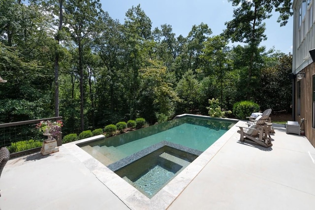 pool with a patio and an in ground hot tub