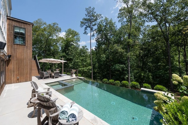 view of pool featuring an in ground hot tub, an infinity pool, and a patio area