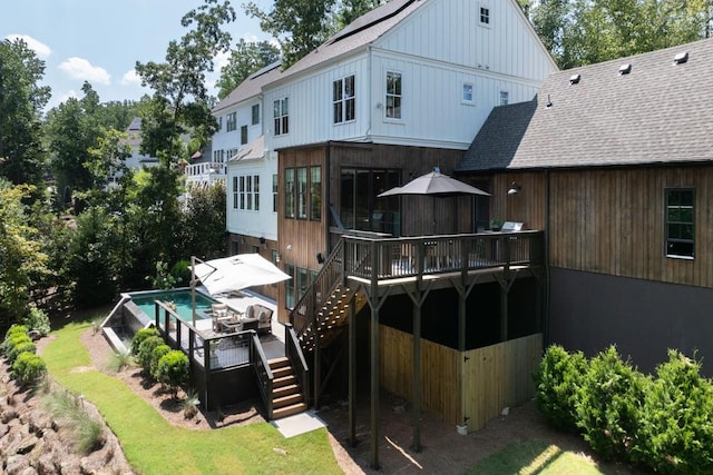 rear view of property with stairs, roof with shingles, and a wooden deck