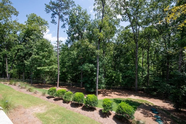 view of yard with fence and a wooded view