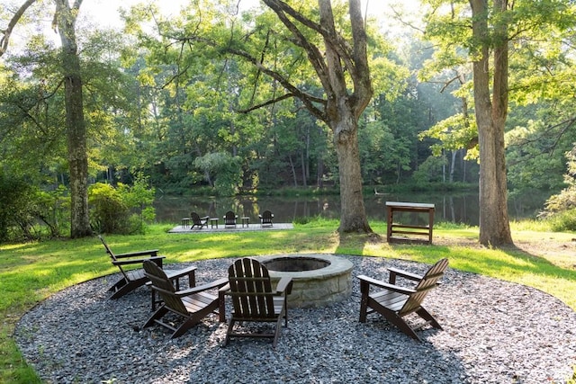exterior space featuring a water view, an outdoor fire pit, and a forest view