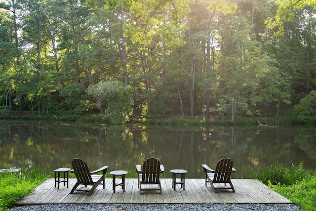 view of dock featuring a water view and a forest view