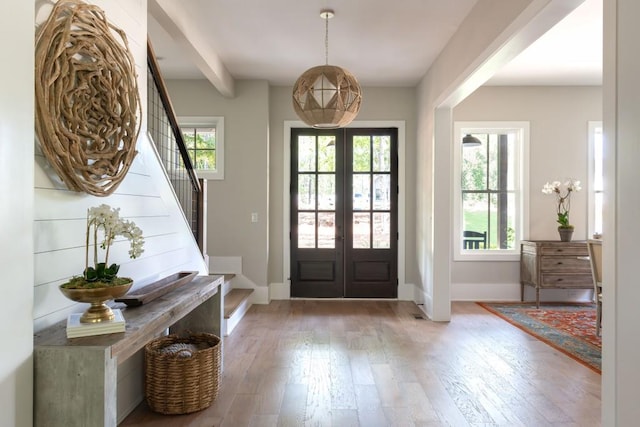 entryway featuring french doors, baseboards, hardwood / wood-style floors, and stairway