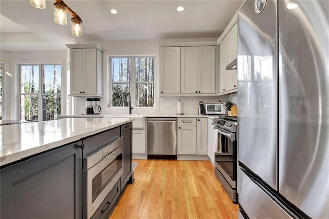 kitchen featuring tasteful backsplash, a healthy amount of sunlight, and appliances with stainless steel finishes