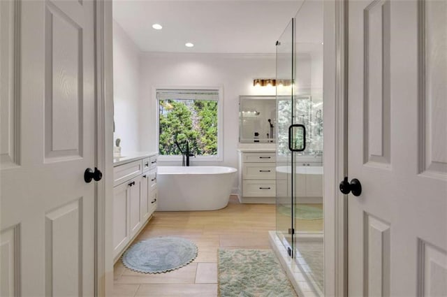 bathroom featuring vanity and independent shower and bath