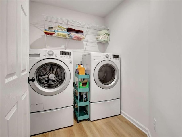 washroom with washer and dryer and light wood-type flooring