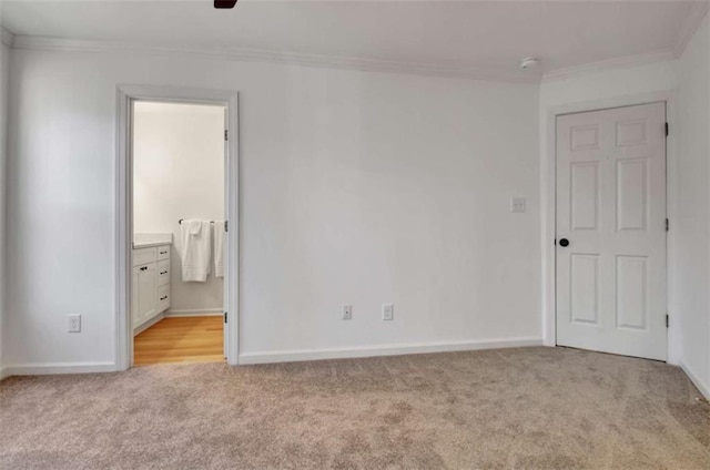 unfurnished bedroom featuring light carpet, ensuite bath, and ornamental molding