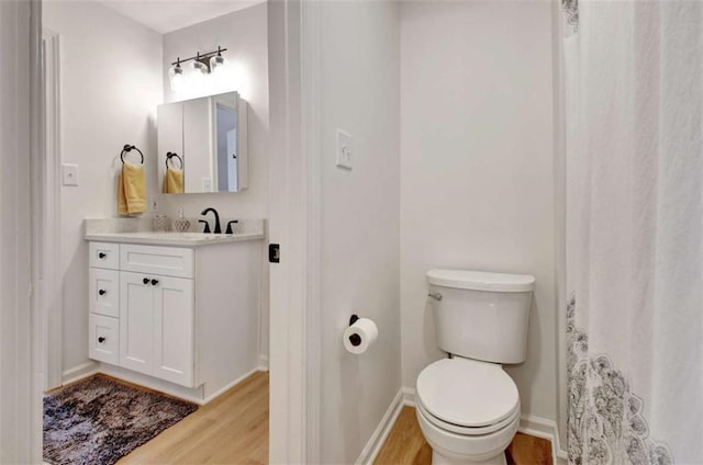 bathroom featuring vanity, hardwood / wood-style flooring, and toilet