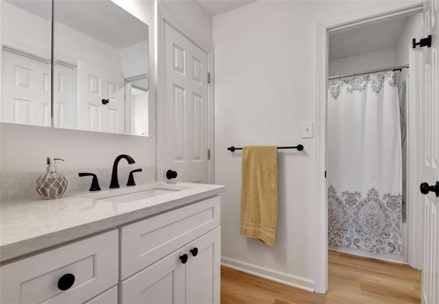 bathroom featuring hardwood / wood-style flooring, vanity, and walk in shower