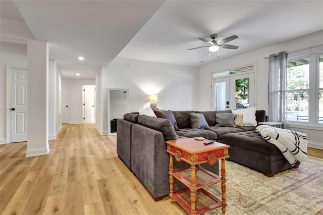 living room featuring french doors, ceiling fan, and light wood-type flooring